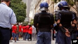 FILE - South African police provide security as Parliament workers, rear, protest against low wages in Cape Town, South Africa, Nov. 11, 2015. 