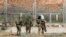 FILE - Israeli soldiers carry away an injured Palestinian who tried to approach the border fence east of Jabalia in the northern Gaza Strip, June 27, 2018.