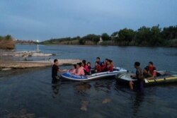 FILE - Asylum-seeking migrant families from Guatemala and Honduras arrive at the U.S. side of the bank on an inflatable raft after crossing the Rio Grande River into the United States from Mexico in Roma, Texas, July 28, 2021.