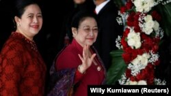 Mantan Presiden Indonesia Megawati Soekarnoputri melambai kepada wartawan saat ia tiba bersama putrinya Puan Maharani, Menteri Koordinator Pembangunan Manusia dan Kebudayaan Indonesia, untuk menghadiri pidato kepresidenan menjelang Hari Kemerdekaan, di ge