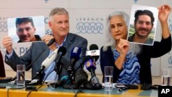 FILE - Marc and Debra Tice, the parents of Austin Tice, who has been missing in Syria since August 2012, hold up photos of him during a news conference at the Press Club in Beirut, Lebanon, July 20, 2017. 