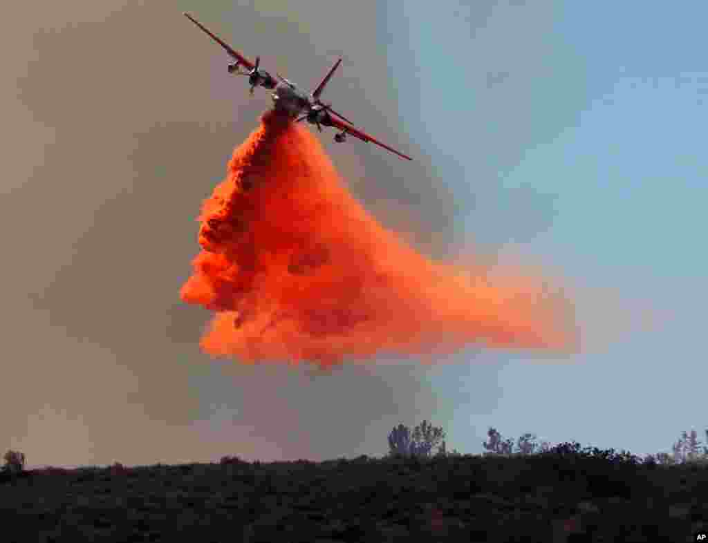 A firefighting plane drops fire retardant on a wildfire in Lancaster, California, June 3, 2013. Firefighters working in darkness doubled containment of a massive wildfire north of Los Angeles to 40 percent overnight, as cool, moist air moved in to replace torrid weather.