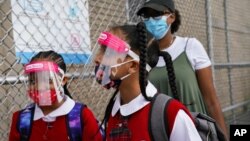 Para siswa mengenakan masker dan pelindung wajah saat tiba untuk belajar di sebuah sekolah di Bronx, New York.