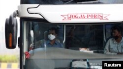 Seorang supir bus mengenakan masker wajah di terminal bus Pulo Gebang di tengah wabah virus corona (Covid-19) di Jakarta, 12 April 2020. (Foto: Reuters)