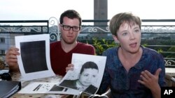 American lawyer, Cori Crider, right, shows a portrait of Younis Abdurrahman Chekkouri a former Guantanamo detainee released from the U.S. detention center.