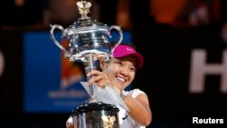 Li Na dari China dengan pialanya setelah mengalahkan Dominika Cibulkova dari Slovakia dalam pertandingan tunggal putri di Australia Terbuka (25/1). (Reuters/Petar Kujundzic)