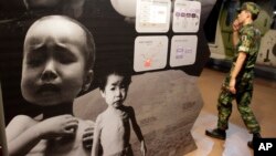 FILE - A South Korean soldier walks by a poster depicting North Korea's food crisis at the Korea War Memorial Museum in Seoul, Sept. 7, 2010. Two U.N. agencies warned May 3, 2019, that more than 10 million North Koreans are facing severe food shortages.