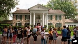 FILE - Fans wait in line outside Graceland, Elvis Presley's Memphis home, in Memphis, Tennessee, Aug. 15, 2017.
