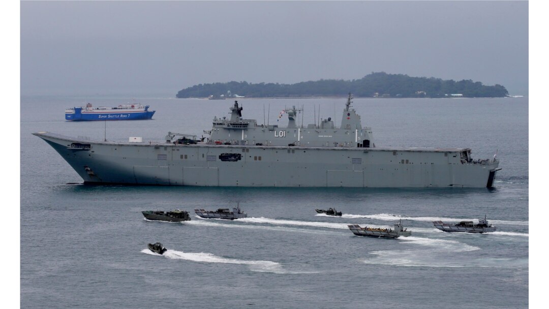 FILE - Royal Australian Navy HMAS Adelaide cruises alongside landing crafts with Philippine Marines and Australian troops as they conduct a joint Humanitarian Aid and Disaster Relief (HADR) exercise off Subic Bay.