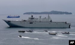 FILE - Royal Australian Navy HMAS Adelaide cruises alongside landing crafts with Philippine Marines and Australian troops as they conduct a joint Humanitarian Aid and Disaster Relief (HADR) exercise off Subic Bay.