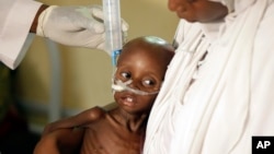 FILE - A doctor feeds a malnourished child at a feeding centre run by Doctors Without Borders in Maiduguri, Nigeria, Aug. 29, 2016.