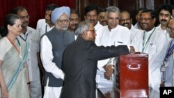 Menteri Keuangan India, Pranab Mukherjee memasukkan surat suaranya di salah satu TPS di New Delhi, disaksikan oleh PM Singh dan presiden kongres India, Sonia Gandhi (19/7).