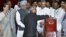 Pranab Mukherjee casts his vote in India's presidential election as PM Singh and Congress party president Sonia Gandhi, along with other lawmakers look on in New Delhi, July 19, 2012. 
