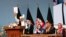 Afghan President Ashraf Ghani holds up the resolution on the last day of an Afghan Loya Jirga or traditional council, in Kabul, Afghanistan, Aug. 9, 2020. 