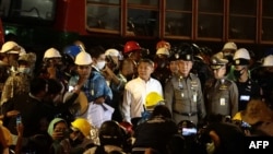 Prateep Kiratilaekha (center, in white), a top aide to Thailand's Prime Minister Prayut Chan-o-cha, listens to a pro-democracy protester (3rd left) during an anti-government rally in Bangkok, Oct. 21, 2020. 