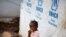 FILE - A girl eats a mango at a shelter for displaced people in Bangui, Central African Republic, April 24, 2017. 