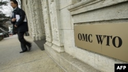 Une personne sort du siège de l'Organisation mondiale du commerce (OMC) à Genève, le 16 décembre 2004. (Photo: FRED DUFOUR / AFP)