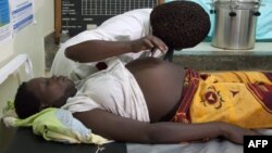 A pregnant woman in Uganda is examined by her doctor. 