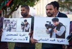Libyan journalists hold placards bearing the portraits of Mohamad al-Gurj and Mohamad al-Shibani, who were detained and their fate remains unknown, during a protest in the capital Tripoli, May 5, 2019.