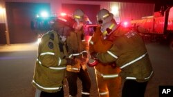 Firefighters at Burragate, Australia, gather outside the firehouse as they discuss a nearby fire threat, Jan. 10, 2020, and where they could retreat.