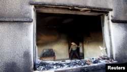 FILE - A Palestinian man inspects a house that was badly damaged in a suspected attack by Jewish extremists on two houses at Duma village near the West Bank city of Nablus, July 31, 2015. 