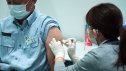 FILE - A Tokyo municipal government employee receives a shot of the Moderna COVID-19 vaccine at a vaccination center at a local government building, in Tokyo, Japan, July 1, 2021.