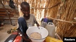 FILE - A boy shows a food ration he received at an internally displaced persons (IDP) camp at Gamboru, Borno state, Nigeria, April 27, 2017.