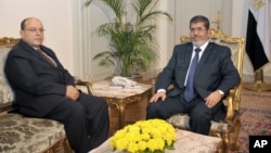 In this photo released by the Egyptian Presidency, President Mohamed Morsi, right, poses for a photograph with his new Prosecutor General, Talaat Abdullah, left, in Cairo, Egypt, Thursday, Nov. 22, 2012.