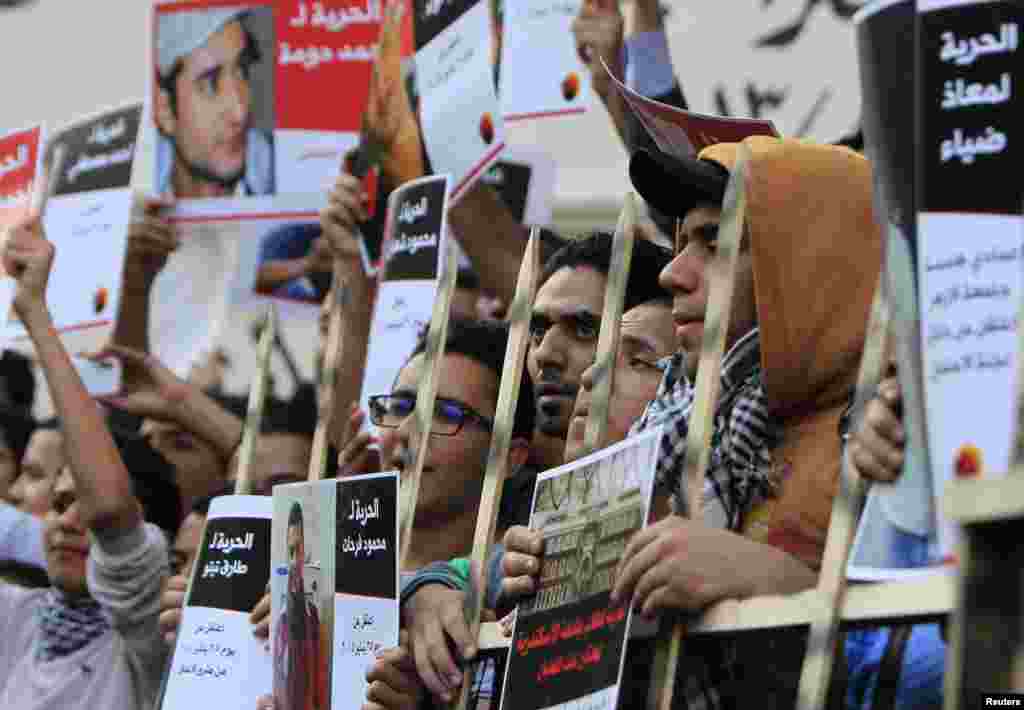 Members of the April 6 movement shout slogans with activists against the government as they protest against the detention of several members of their movement in front of the Press Syndicate building in Cairo, April 6, 2014. 