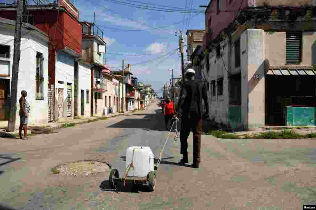 Un hombre tira de un carrito con un contenedor de agua que consiguió gracias a un grupo de la iglesia que asiste a los residentes con pequeñas cantidades de líquido para frenar la escasez. En La Habana, Cuba, el 12 de septiembre de 2024.