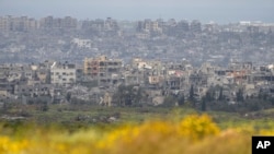 FILE— Destroyed buildings stand in the Gaza Strip as seen from southern Israel, March 18, 2024.