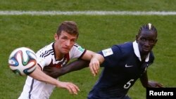 Mamadou Sakho, joueur de la France, à droite, engagé dans un duel avec Thomas Mueller de l'Allemagne, lors du match des quarts de finale du Mondial de football, au stade Maracana à Rio de Janeiro, Brésil, 4 Juillet 2014.