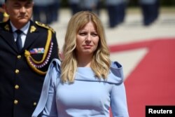 FILE - Slovakia's President Zuzana Caputova reviews the guard of honor at the Presidential Palace after her swearing-in ceremony in Bratislava, Slovakia, June 15, 2019.