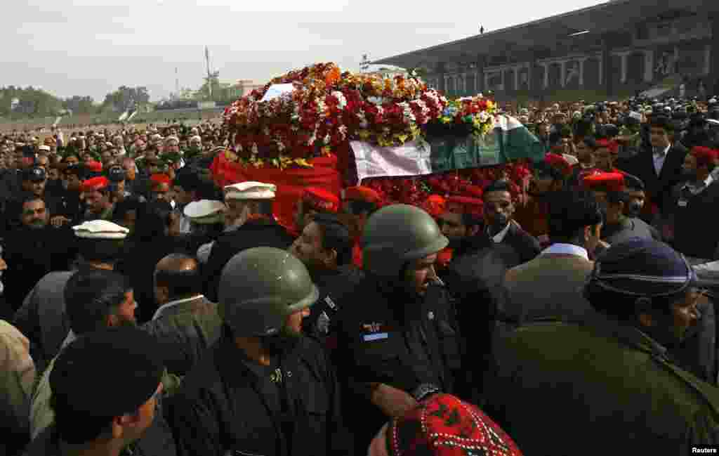 People carry the coffin of the provincial minister for local government Bashir Ahmad Bilour, who died of his wounds from a bombing attack, during his funeral at the Army Stadium in Peshawar December 23, 2012. Taliban Islamic militants bombed a political r