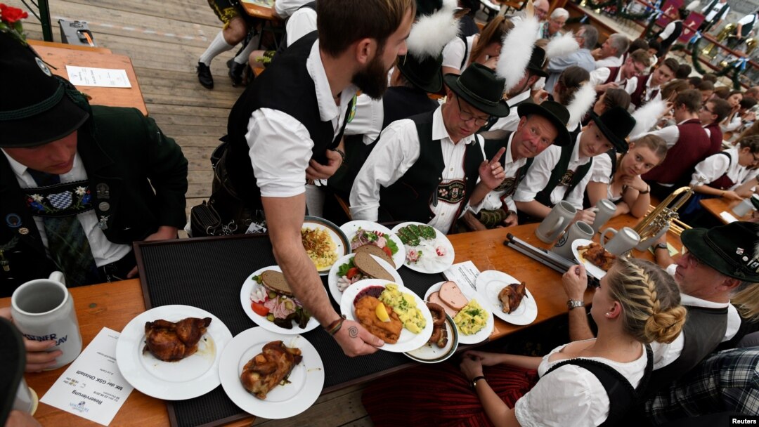 Para peserta parade Oktoberfest tampak di sebuah tenda dalam perayaan festival bir terbesar di dunia, yang digelar di Munich, Jerman, 23 September 2018.