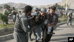 Afghan security forces carry a wounded police man at the site of a suicide attack outside The British Council in Kabul, Afghanistan, August 19, 2011