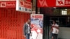 FILE - A man checks his mobile phone outside an internet cafe in Harare, Zimbabwe, January 21, 2019. 