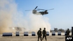 Les troupes américaines près de leur hélicoptère C-47 Chinook survolant le village d'Oreij, au sud de Mossoul, le 22 février 2017