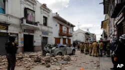 Equipos de rescate junto a un automóvil aplastado por los escombros después de un terremoto en Cuenca, Ecuador, el sábado 18 de marzo de 2023. (Foto AP/Xavier Caivinagua)