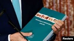 U.S. Secretary of State John Kerry holds a copy of the 2016 Trafficking in Persons. (File)