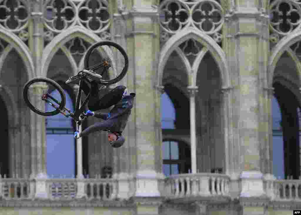 Seorang peserta berlatih dengan sepedanya dalam acara gaya bebas Vienna Air King yang diselenggarakan perusahaan Red Bull di depan gedung pertemuan Rathaus di Vienna, Austria. 