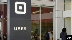 People make their way into the building that houses the headquarters of Uber, June 21, 2017, in San Francisco.