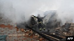 A rescuer of the State Emergency Service works to put out a fire in a private house after a drone strike in Kharkiv, Ukraine, on Dec. 25, 2024.