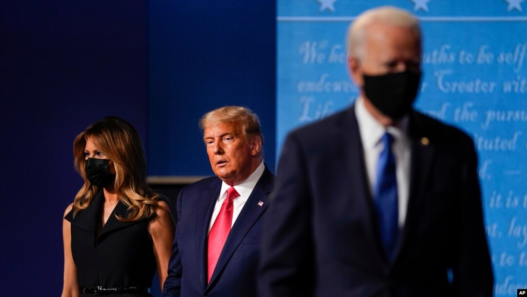 Ibu Negara Melania Trump, kiri, dan Presiden Donald Trump, tengah, tetap berada di atas panggung saat calon presiden dari Partai Demokrat, mantan Wakil Presiden Joe Biden, kanan, pergi pada akhir debat presiden kedua dan terakhir. (Foto: AP)