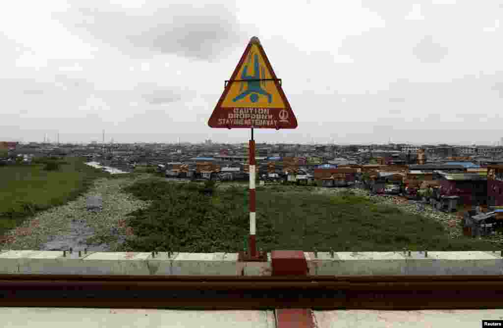 A warning sign overlooking a slum is seen on a light rail track under construction at the Orile-Iganmu district of Lagos.