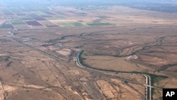 FILE - In this Oct. 8, 2019 photo, the Central Arizona Project canal runs through rural desert near Phoenix, Arizona.