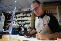Gun Central general manager Michael McIntyre examines and registers a handgun for sale following the attack that killed 22 people in a Walmart on August 3, in El Paso, Texas, Aug. 12, 2019.