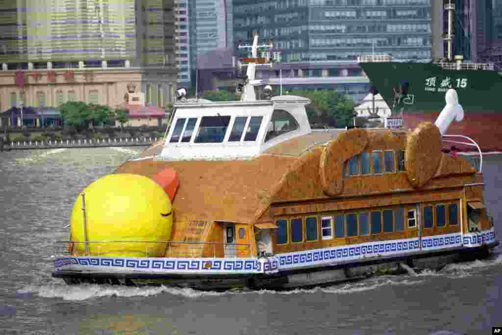 Sebuah kapal feri dihias agar terlihat seperti bebek panggang di Sungai Huangpu di Shanghai, China.