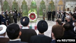 Mourners and members of Iranian forces stand around the coffin of Iranian nuclear scientist Mohsen Fakhrizadeh at the Imam Khomeini's Shrine in Tehran, Nov. 29, 2020.