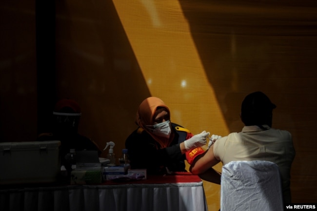 Seorang buruh divaksinasi COVID-19 di sebuah pabrik di Sumedang, Jawa Barat, 5 Agustus 2021. (REUTERS)